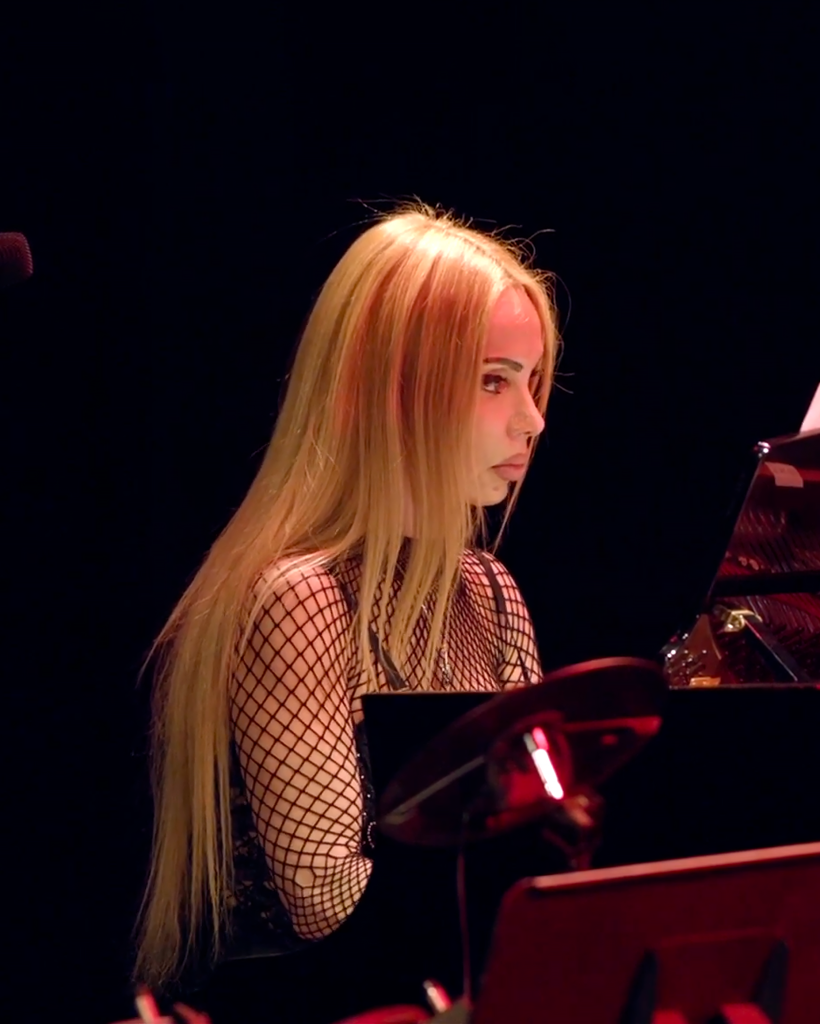 photo d'une prof de piano à Cannes jouant dans une salle de concert sombre